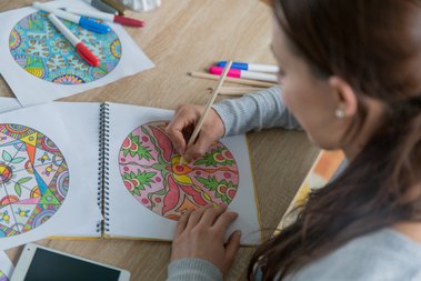 mulher colorindo um desenho de mandala