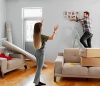 homem e mulher pendurando painel de fotos na parede