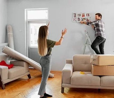 homem e mulher pendurando painel de fotos na parede