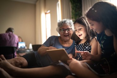 senhora olhando tablet com duas crianças