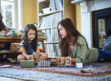 mulher e criança brincando no chão