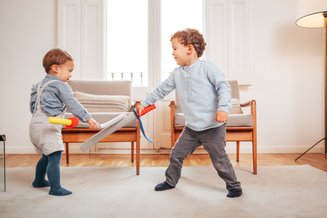 duas crianças brincando com espadas de brinquedo