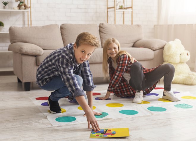 menino e menina no chão brincando de twister