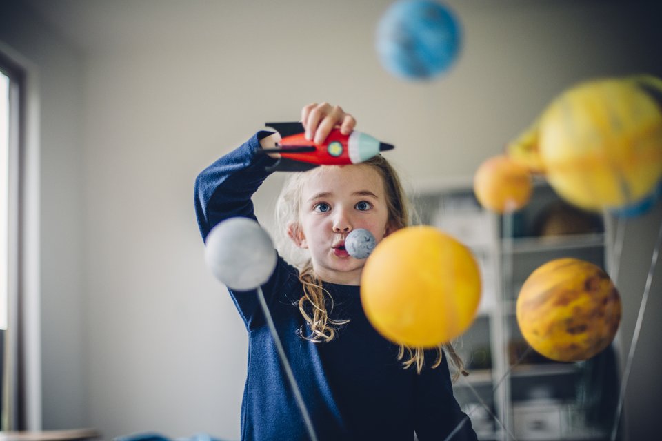 criança brincando com foguete de brinquedo