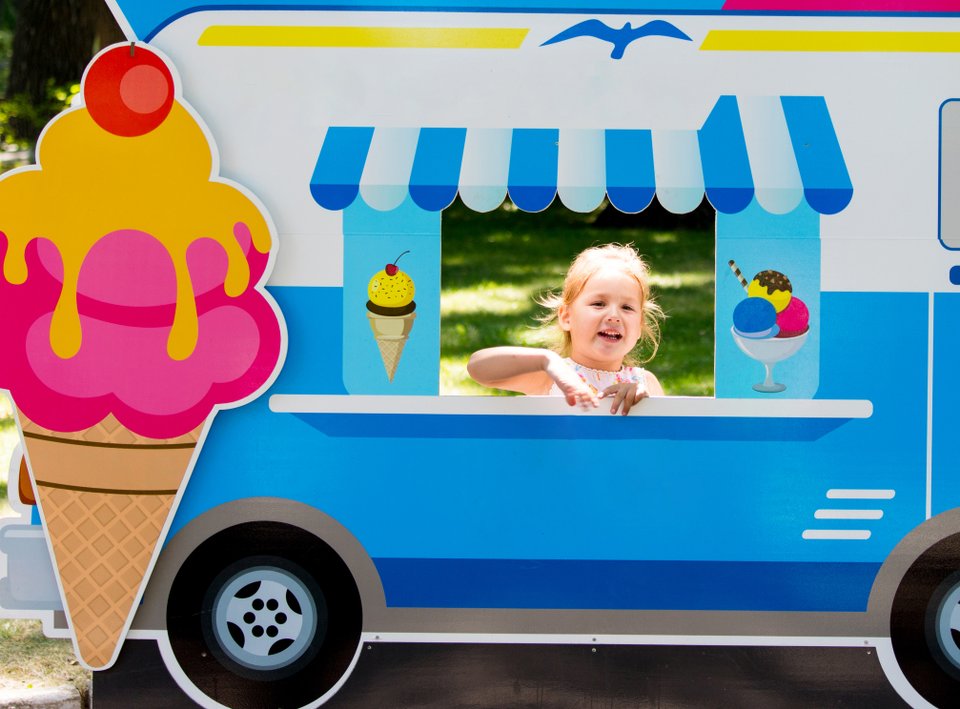 criança atrás de um papelão em formato de food truck