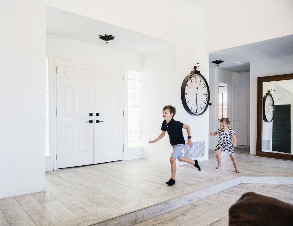 duas crianças correndo na sala de casa