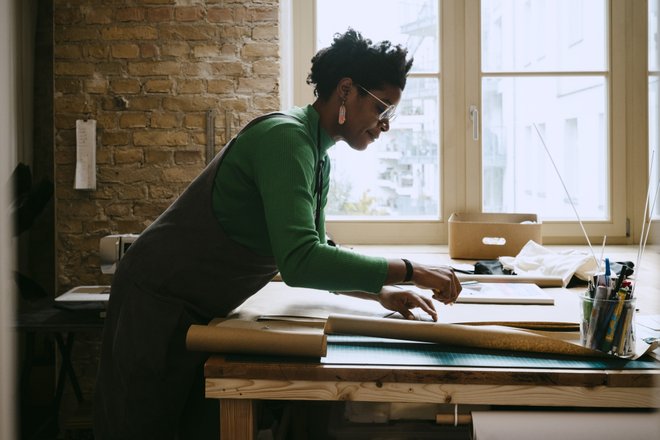 mulher usando uma mesa e mexendo com papel para artesanato