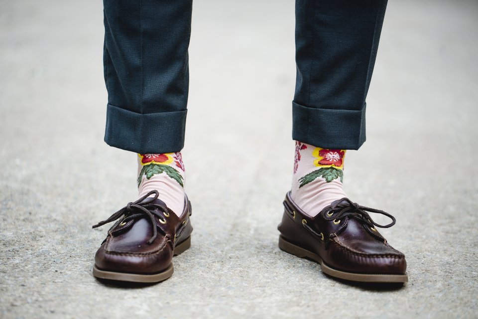 close nos pés de uma pessoa usando um loafer, meias coloridas e calça curta skine