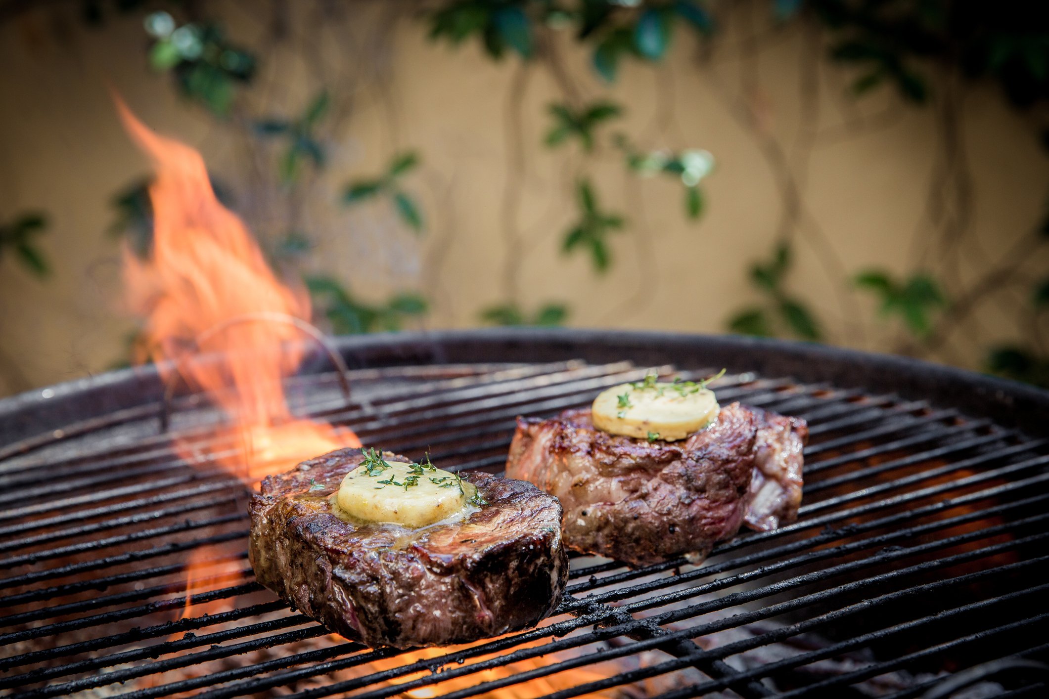 churrasqueira com carne na grelha e um fogo ultrapassando a grelha