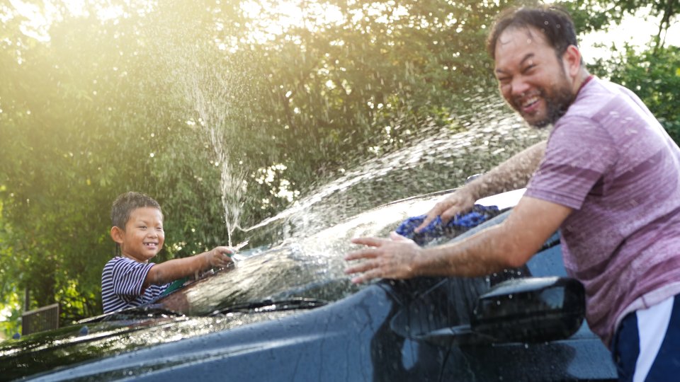 homem e criança lavando carro