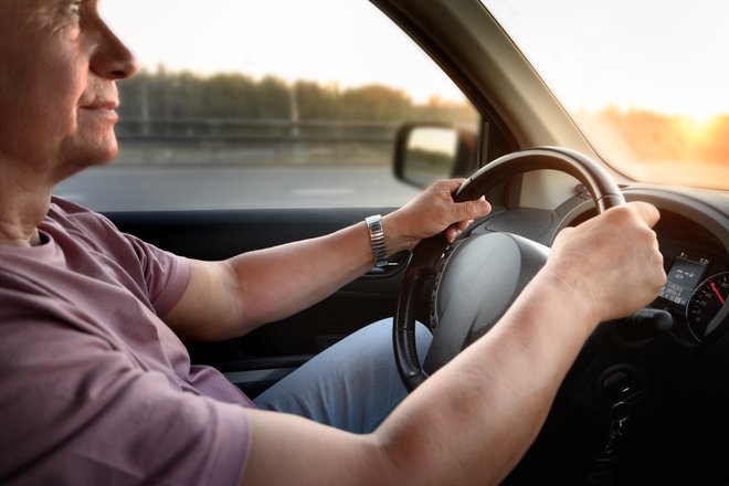 motorista segurando o volante de um carro