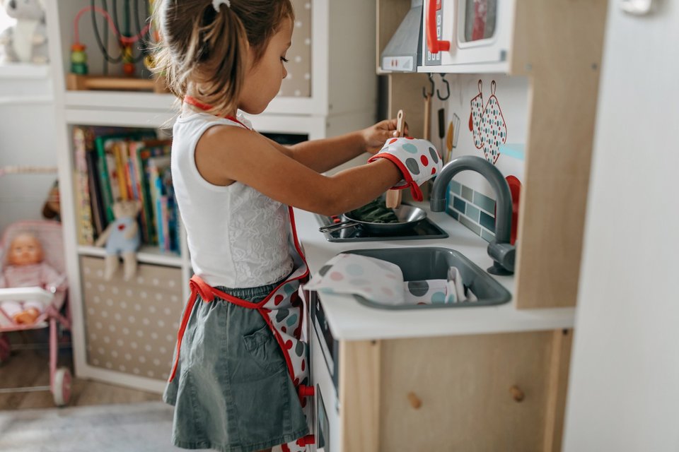 criança brincando com cozinha de brinquedo