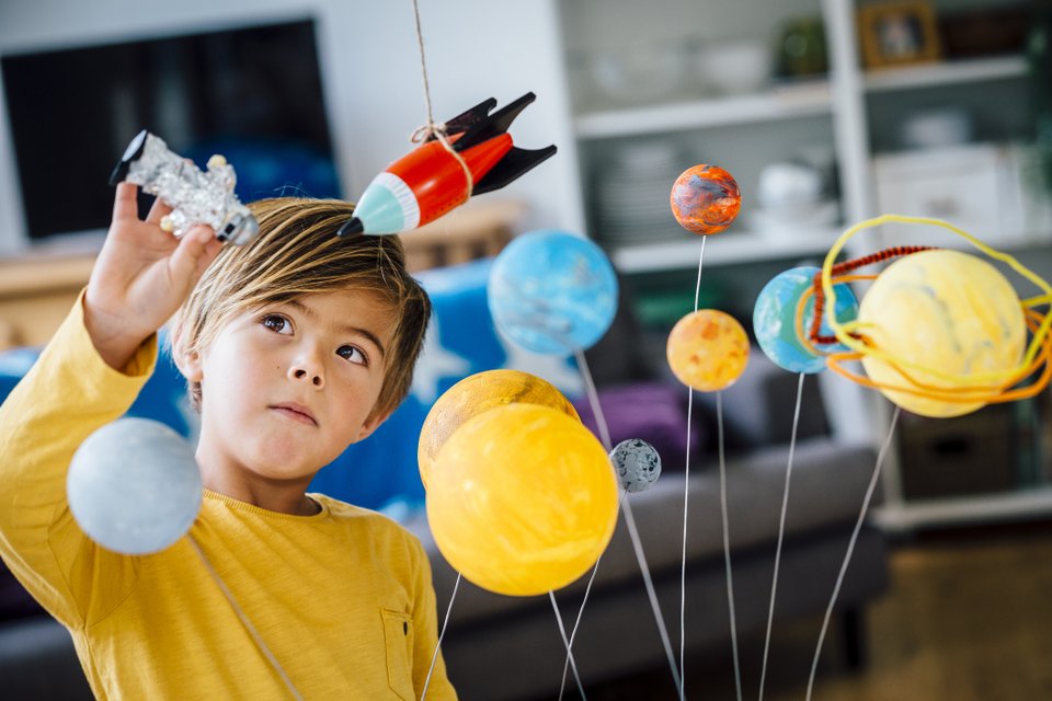 criança brincando com nave espacial de brinquedo