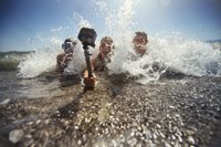 três pessoas na praia usando Bastão flutuante