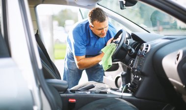 homem limpando volante de carro