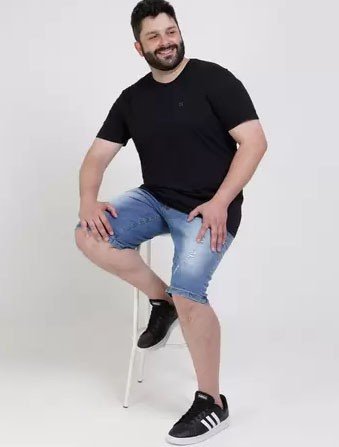homem sentado em banco com bermuda jeans e camiseta preta