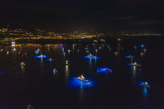 vários barcos com luzes azuis no mar