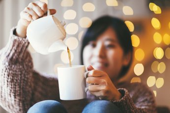 mulher colocando chá na caneca