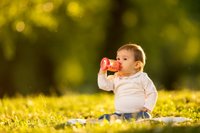 criança bebendo suco em um copo com alça