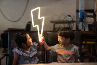 duas crianças segurando um raio de eletricidade