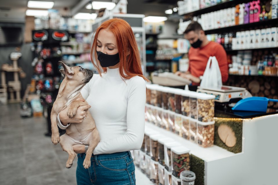 mulher segurando cachorro dentro de pet shop