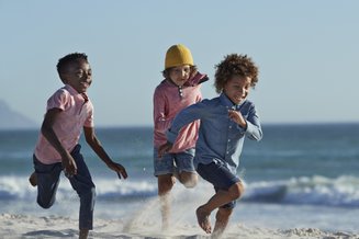 crianças correndo na praia 