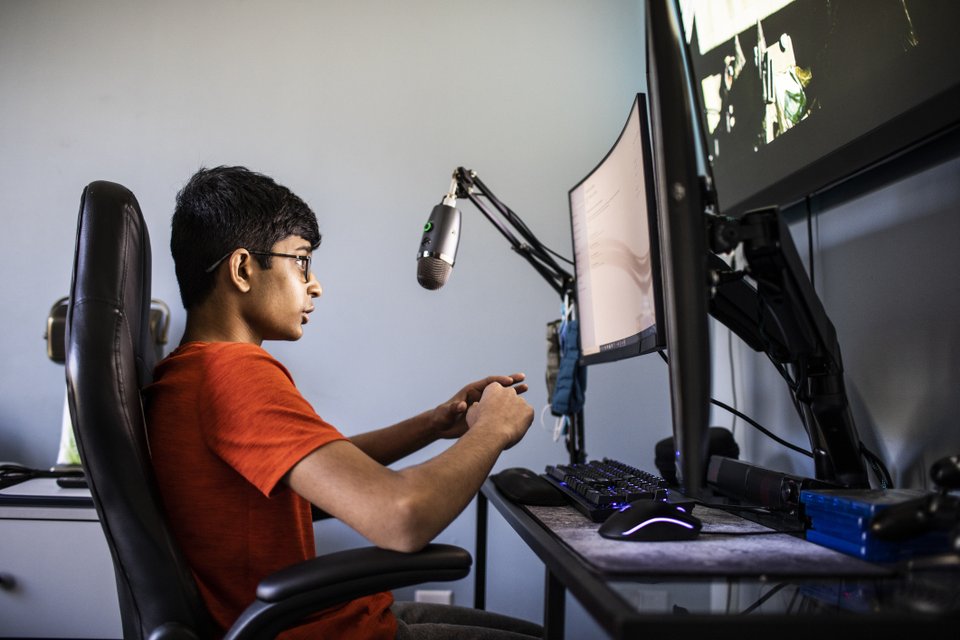 criança em frente ao computador com várias telas