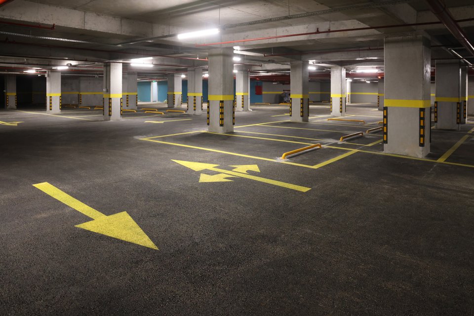 estacionamento com setas no chão e protetores de para-choque