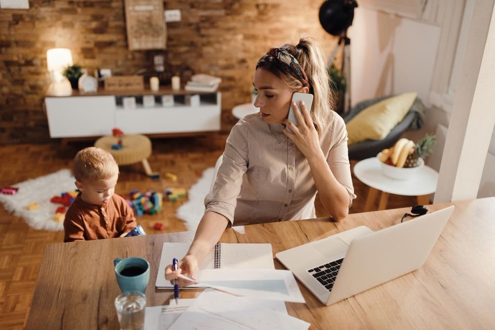 Mulher trabalhando em casa e escrevendo em um caderno de disco enquanto organiza tarefas no ambiente de home office