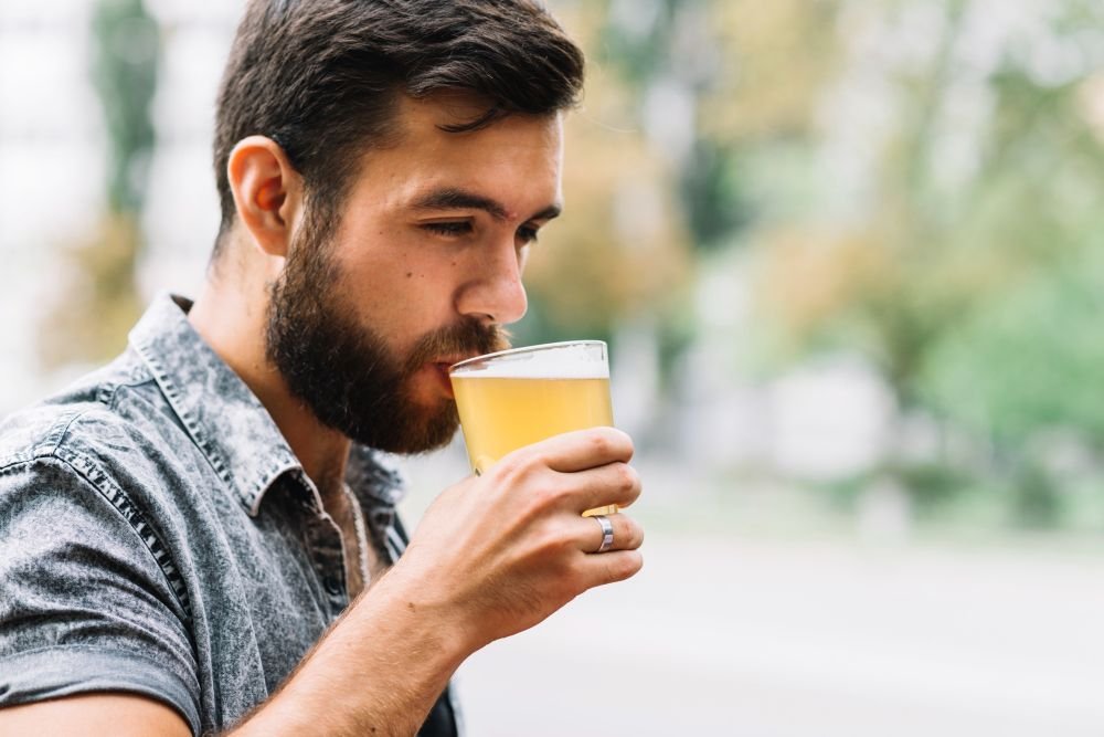 Homem tomando copo de cerveja sem a&ccedil;&uacute;car