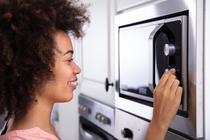 mulher ajustando a temperatura no microondas