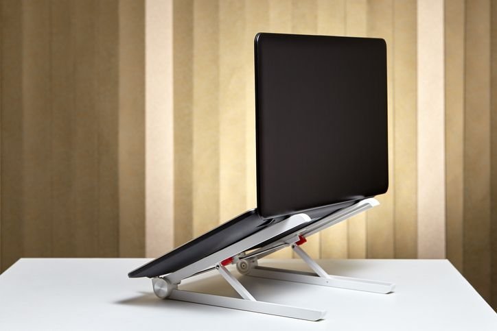 Imagem de uma base para notebook com laptops sobre ela, ideal para suporte e organização de dispositivos tecnológicos.