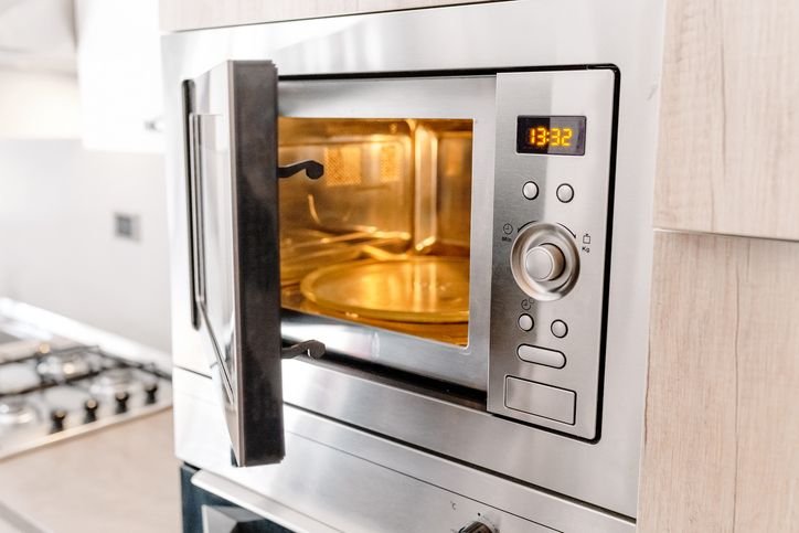 Prato de comida sendo aquecido dentro de um micro-ondas em funcionamento.