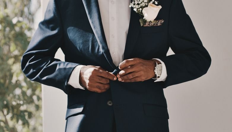 Homem abotoando o paletó de terno masculino pra casamento