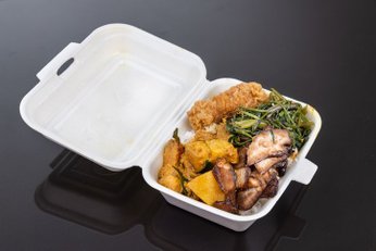 marmita com comida dentro em cima de uma mesa preta