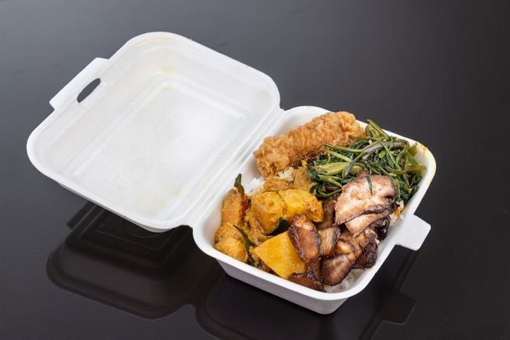 marmita com comida dentro em cima de uma mesa preta