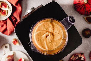 Liquidificador batendo uma mistura cremosa e homogênea na jarra, mostrando o desempenho de um modelo Philips Walita 1200W no preparo de receitas.