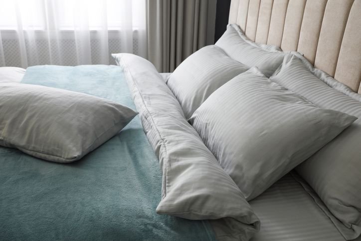 Cama king com jogo de cama azul e cinza