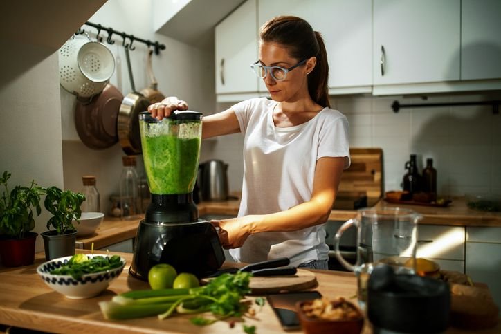 Liquidificador Philips Walita 1200W sobre a bancada, batendo uma mistura verde em uma cozinha dom&eacute;stica.