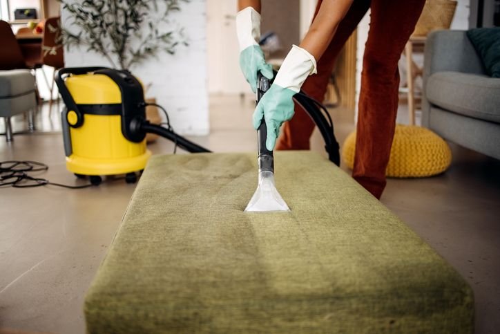 Aspirador de pó e água com bico plástico sob uma superfície de tecido, ideal pra manutenção de ambientes domésticos ou comerciais.