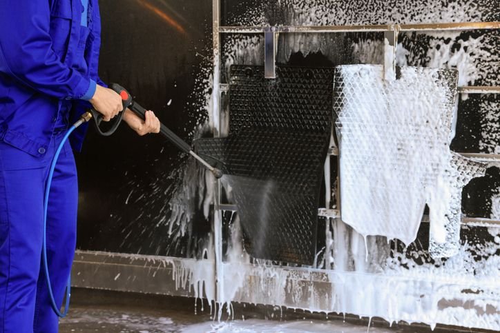Homem lavando tapete de carro com Lavadora alta press&atilde;o com snow foam: