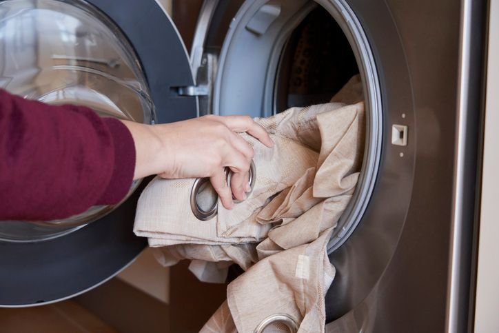 Pessoa colocando roupas na lava e seca Electrolux, m&aacute;quina de lavar roupas moderna e eficiente pra facilitar a rotina de lavanderia. 