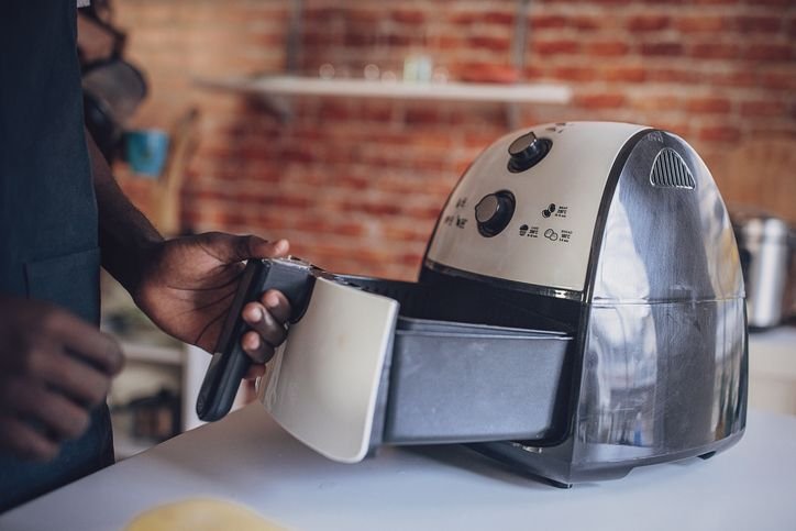 Homem abrindo uma air fryer WAP barbecue