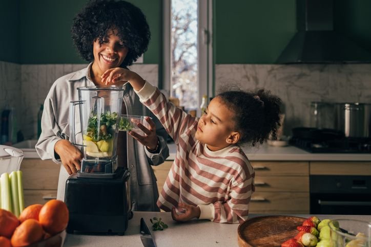 Mâe e filha usando o liquidificador na cozinha