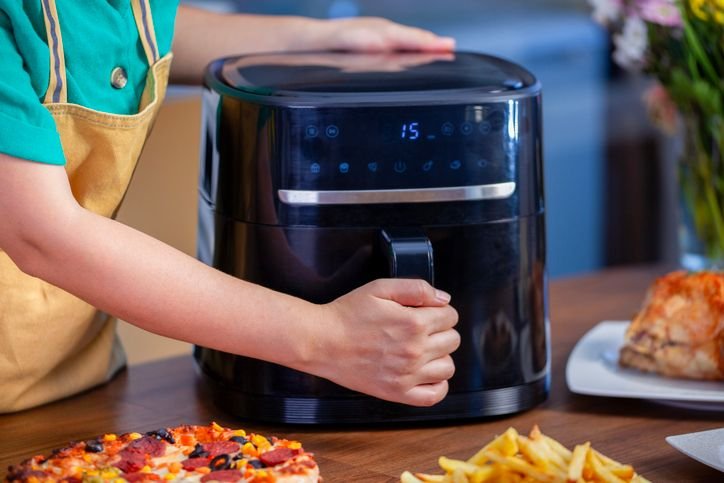 Air fryer forno com acabamento em inox e preto, cestos duplos e design moderno sobre a bancada da cozinha. 