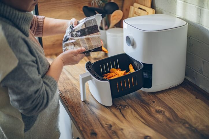 Air fryer aberta sobre a bancada da cozinha, representando a busca por uma air fryer que não enferruja