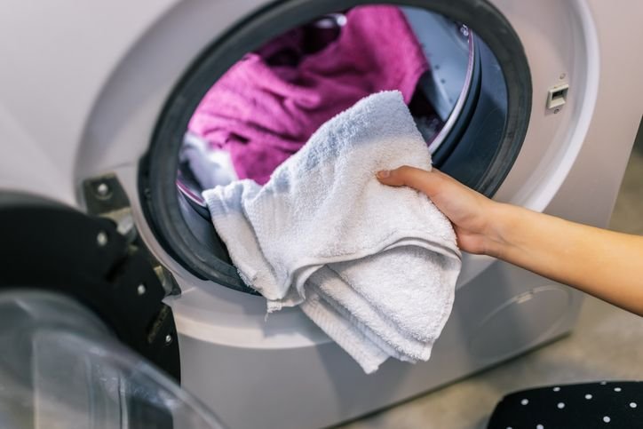 Lavadora de roupa lava e seca 12kg com carga de roupas sujas na lavanderia, ideal para otimizar espa&ccedil;o e facilitar o dia a dia dom&eacute;stico.  