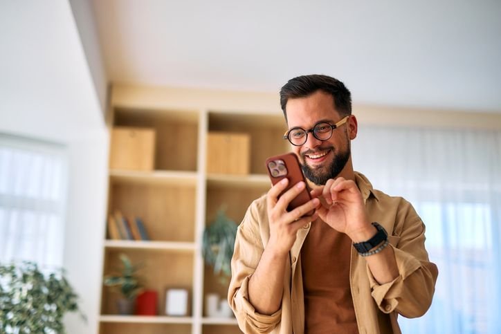 Homem de perfil usando smartphone Poco X7 em sua casa