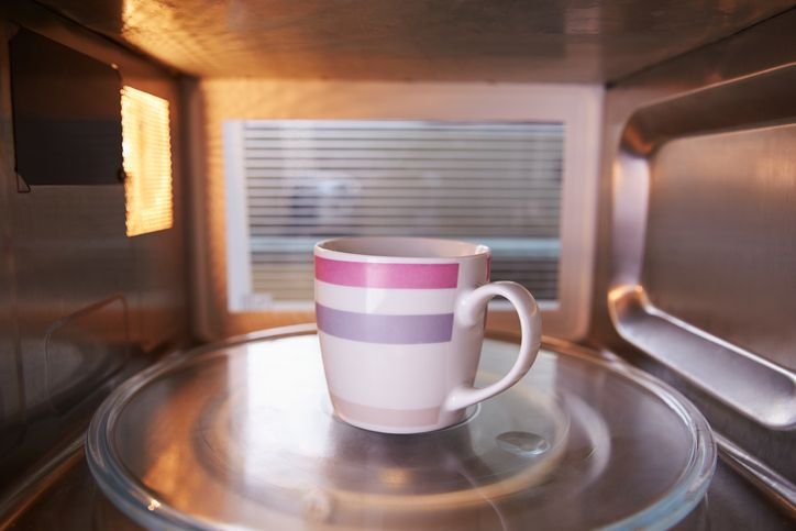 caneca com listra rosa e roxa dentro de um microondas