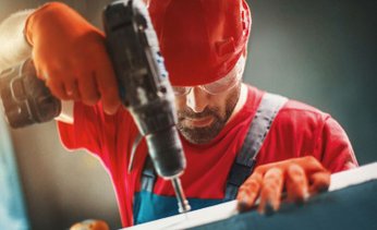 Profissional usando uma parafusadeira elétrica em um trabalho manual, mostrando como a ferramenta certa facilita o serviço e garante um resultado bem feito.